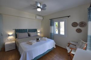 a bedroom with a white bed with a ceiling fan at Anastasia Home in Triandáros