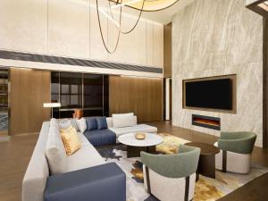 a living room with a couch and a tv at Pullman Ambassador Seoul Eastpole in Seoul