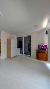 an empty living room with a white floor and a tv at Guest House Nadol SUP and Bikes included in Ohrid