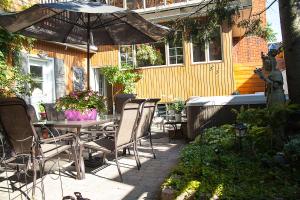 a patio with a table and chairs and an umbrella at Maison Des Jardins B & B in Montreal
