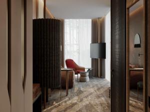 a living room with a red chair and a window at Mövenpick Yerevan in Yerevan