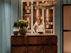 a woman is standing behind a counter in a room at Mövenpick Yerevan in Yerevan