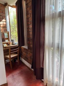 a room with a desk and a window with curtains at La Misión Hotel Chignahuapan in Chignahuapan