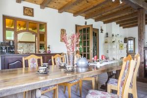 a dining room with a wooden table and chairs at Chatka Mysliwego Wladka in Wola Piotrowa