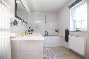 a white bathroom with a sink and a tub at Chatka Mysliwego Wladka in Wola Piotrowa +42 photos