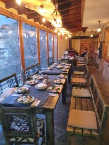 a long dining room with a long table and chairs at Rhodope House Momchil Yunak in Momchilovtsi +19 photos