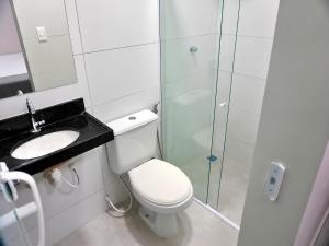 a bathroom with a toilet and a glass shower at Hotel Campina Center in Campina Grande