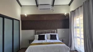 a bedroom with a large bed and a window at La Palma Suites Guest House in Mochudi