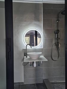 a bathroom with a sink and a mirror at La Palma Suites Guest House in Mochudi