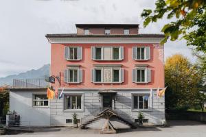 a large pink and white building with a staircase in front at Boutique Hotel Waldegg in Lucerne