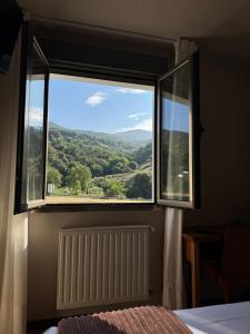 a bedroom with a large window with a view at Hotel Montaña Central in Caborana