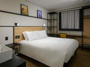 a large white bed in a hotel room at Ibis Caruaru in Caruaru +28 photos