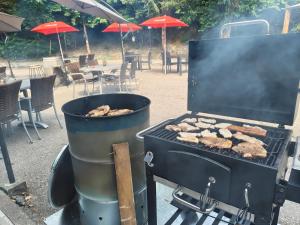 a grill with some chickens cooking on it at Locanda EL TORO in Arnoldstein