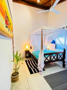 a bedroom with a bed with a mosquito net at Onadi House in Galle