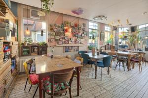 a restaurant with tables and chairs in a room at Be my Guest House in Wijk aan Zee