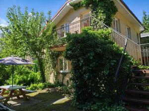 a house with an umbrella and a table and a stairs at Olimpia Pobierowo in Pobierowo