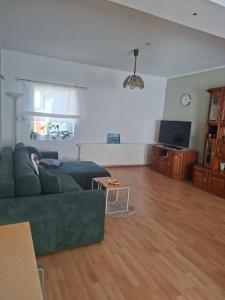 a living room with a green couch and a table at Ferienhaus Petig in Pritzerbe