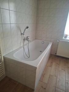 a bath tub with a shower in a bathroom at Ferienhaus Petig in Pritzerbe +25 photos