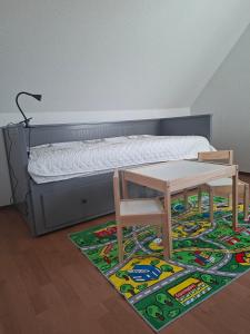 a bedroom with a bed and a table and a rug at Ferienhaus Petig in Pritzerbe