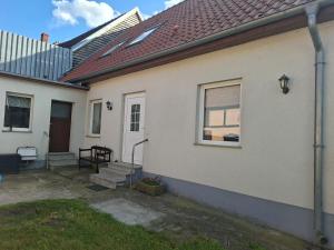 a white house with a window and a patio at Ferienhaus Petig in Pritzerbe