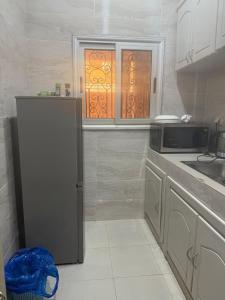 a kitchen with a refrigerator and a microwave at Villa S in Ouagadougou