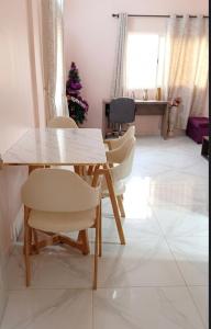 a table and chairs in a living room with a christmas tree at Villa S in Ouagadougou