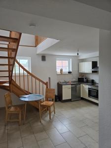 a kitchen with a staircase and a table and chairs at Ferienhaus An der Teufelsklippe in Veckenstedt