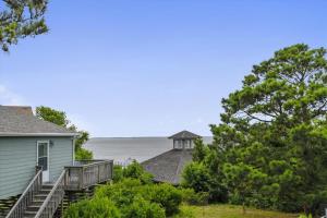 a house with a dock next to the water at Hurricane Charlie's in Duck