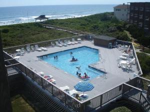 a swimming pool with people in it next to the beach at Hurricane Charlie's in Duck
