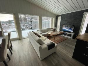 a living room with a couch and a tv at Flott hytte på Bjørgan in Grong