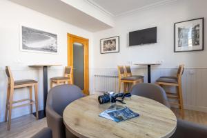 a dining room with a wooden table and chairs at Hotel La Terraza in Miño