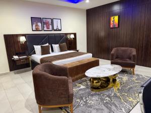 a hotel room with a bed and two chairs and a table at Vinpy hotels in Uyo +48 photos