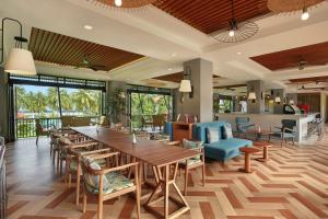 マナドにあるManado Tateli Resort and Conventionの大きな木製テーブルと椅子が備わるレストラン