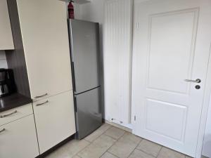 a kitchen with a refrigerator next to a door at Ferienhaus An der Teufelsklippe in Veckenstedt +7 photos