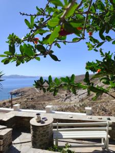 a white bench with a view of the ocean at Πέτρινο in Tinos