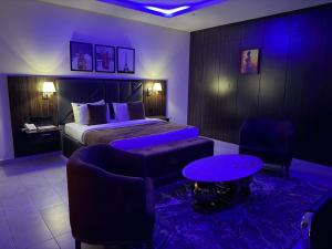 a hotel room with a bed and a table and chairs at Vinpy hotels in Uyo
