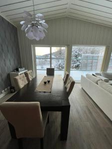 a dining room with a table and chairs and a couch at Flott hytte på Bjørgan in Grong