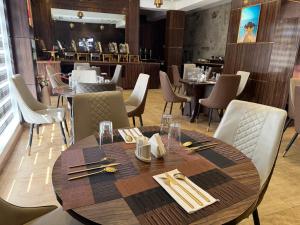 a dining room with a wooden table and chairs at Vinpy hotels in Uyo