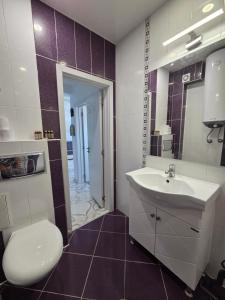 a bathroom with a white toilet and a sink at Siyana Obzor in Obzor +13 photos