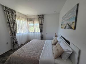 a bedroom with a bed and a large window at Siyana Obzor in Obzor