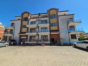 a large building with cars parked in front of it at Siyana Obzor in Obzor