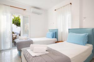 two beds in a room with a window at To Steno in Kamares
