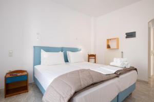 a bedroom with a large bed with a blue headboard at To Steno in Kamares +29 photos