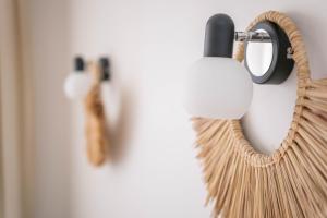 a wicker mirror hanging on a wall at Freda Self Check-in in Nida