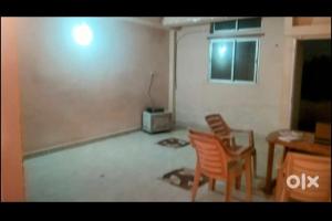 a living room with two chairs and a table at OM Tower in Jamshedpur +2 photos