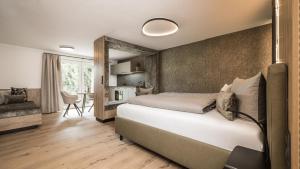 a bedroom with a large bed and a kitchen at apartments '43 in Reith im Alpbachtal