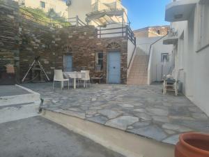 a patio with a table and chairs and a building at Nautilus andros house in Andros