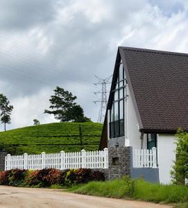 a white house with a white fence and a hill at Annfield Cabana in Hatton