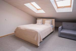 a attic bedroom with a bed and a chair at Freda Self Check-in in Nida