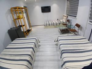 a room with three beds in a room with a tv at Guest House "Markaz" in Khorog